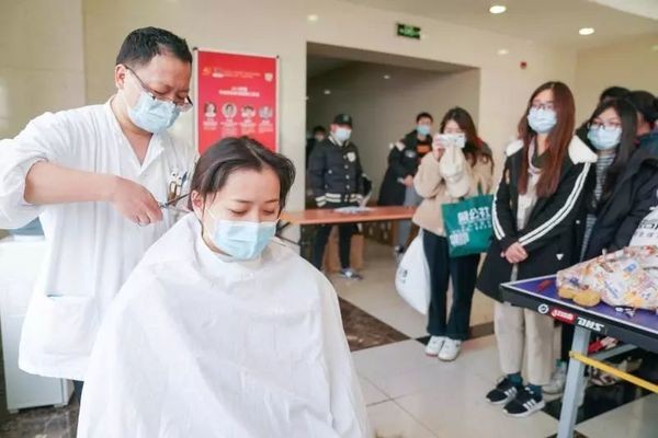 醫護人員一個個排著長長的隊伍,等待理髮師把青絲剪短。