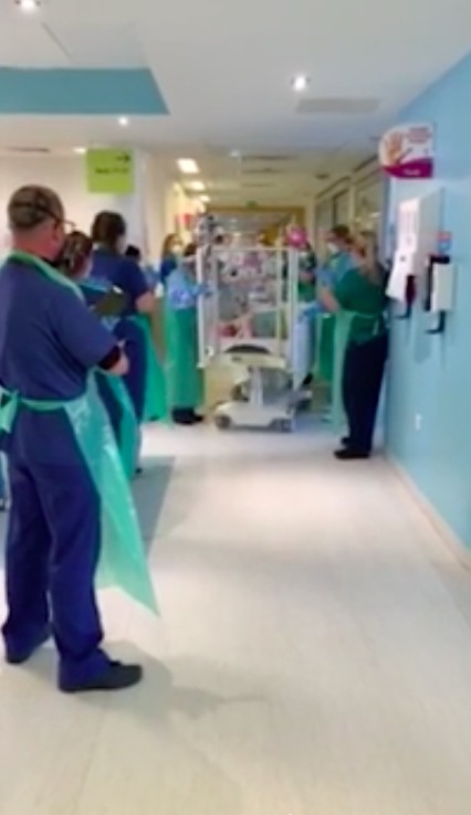 不少醫護站在走廊兩旁,為這名小小生命鬥士鼓掌。