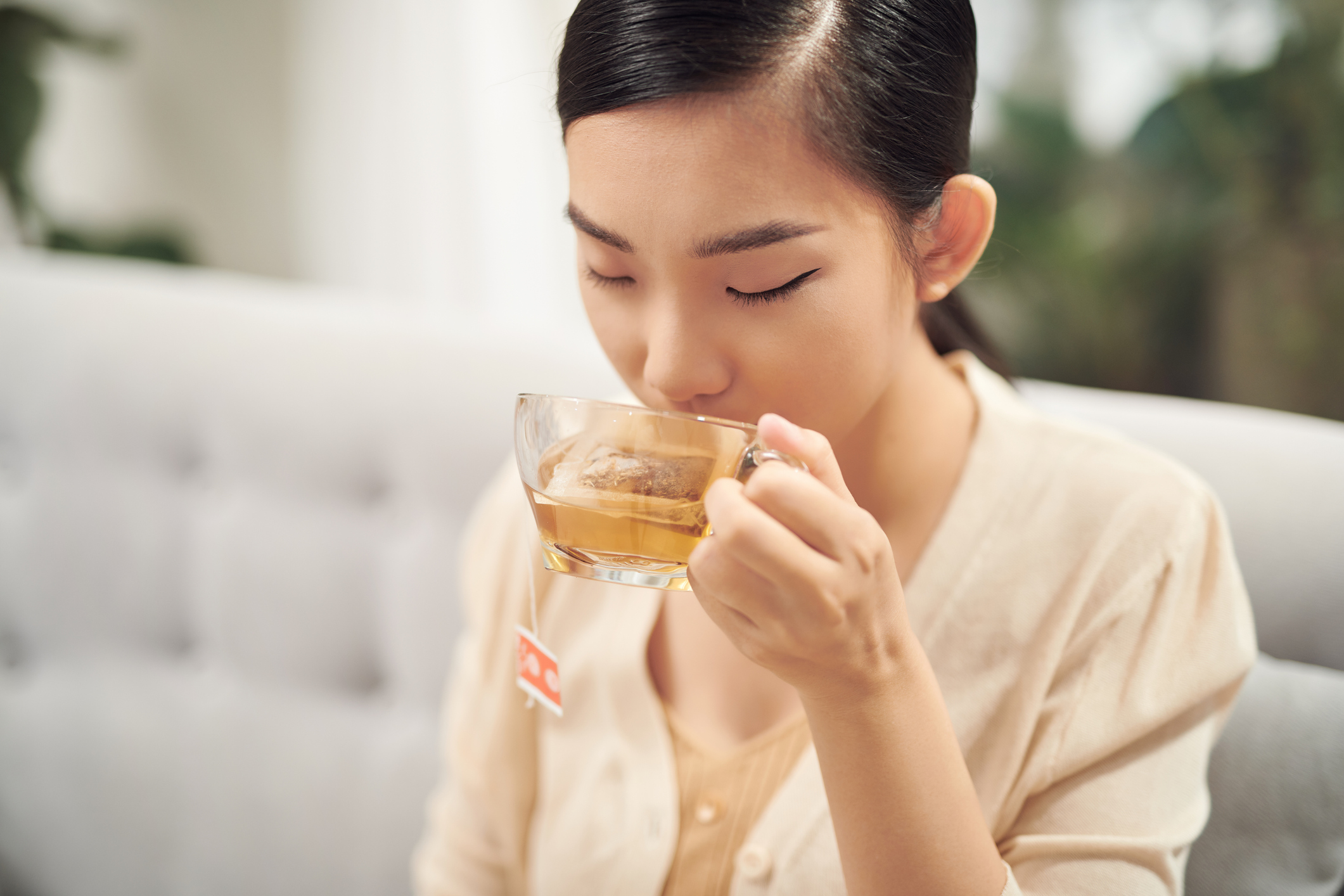 Beautiful Young Woman drinking hot tea
