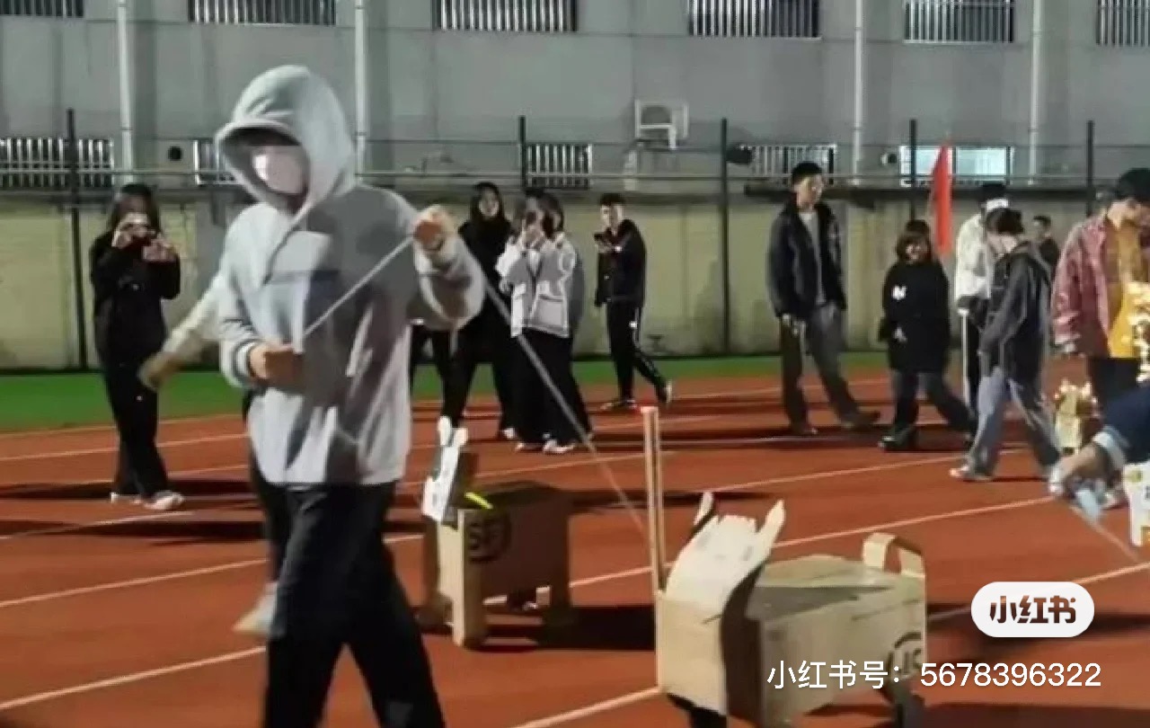 大學生在操場上舉行「遛狗大賽」。