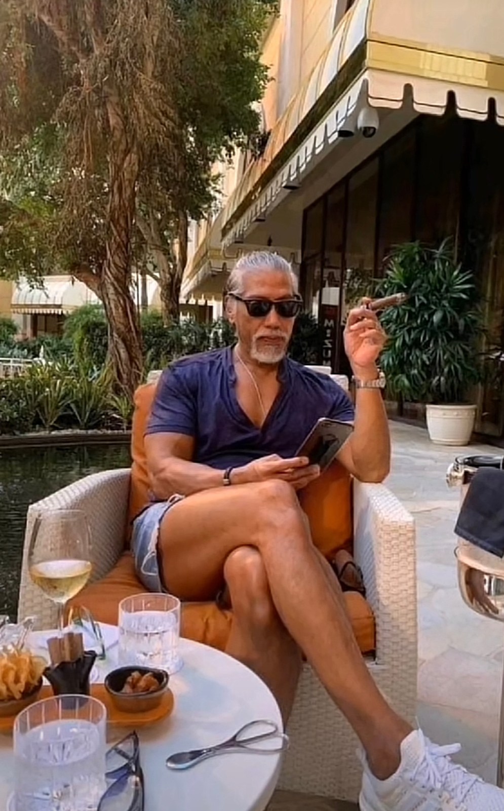 低胸緊身上衣+左手拿著雪茄，那股氣勢不輸當年。