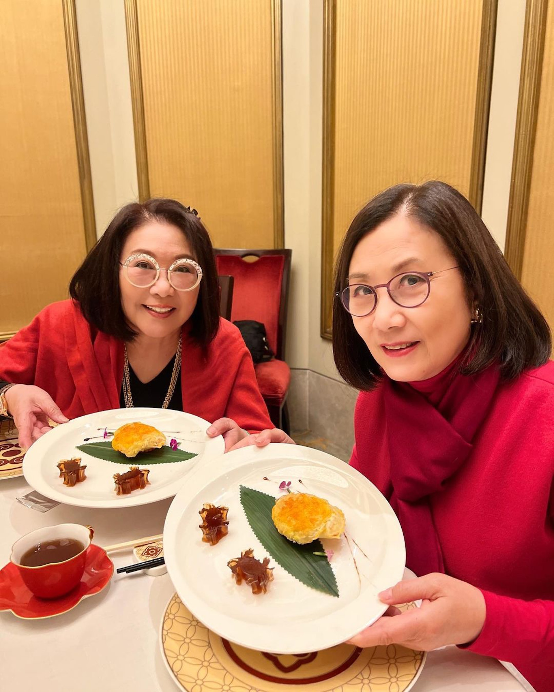 2人默契同穿紅衫、搭配圓型眼鏡、髮型相似,被網民讚似Twins。