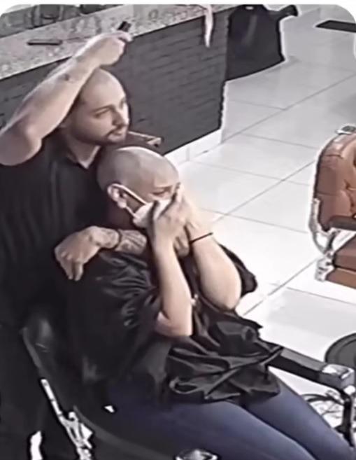 理髮師伸出另一隻手挽住了她，畫面十分感人。