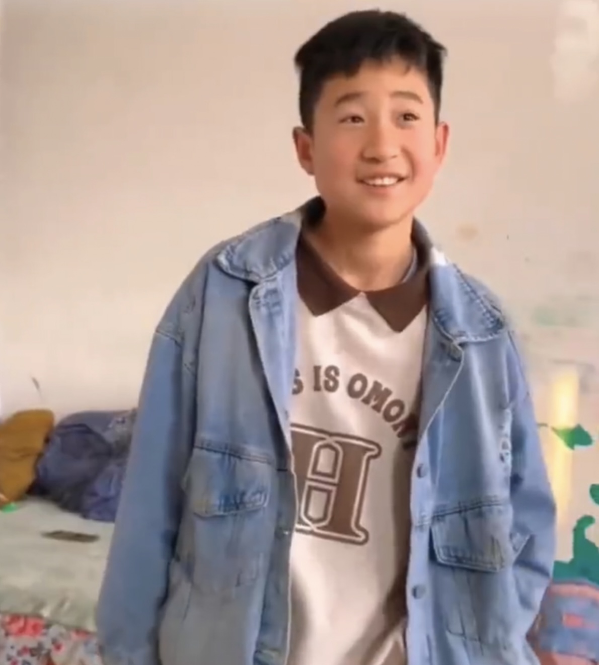 少年面對稱讚笑容靦腆。