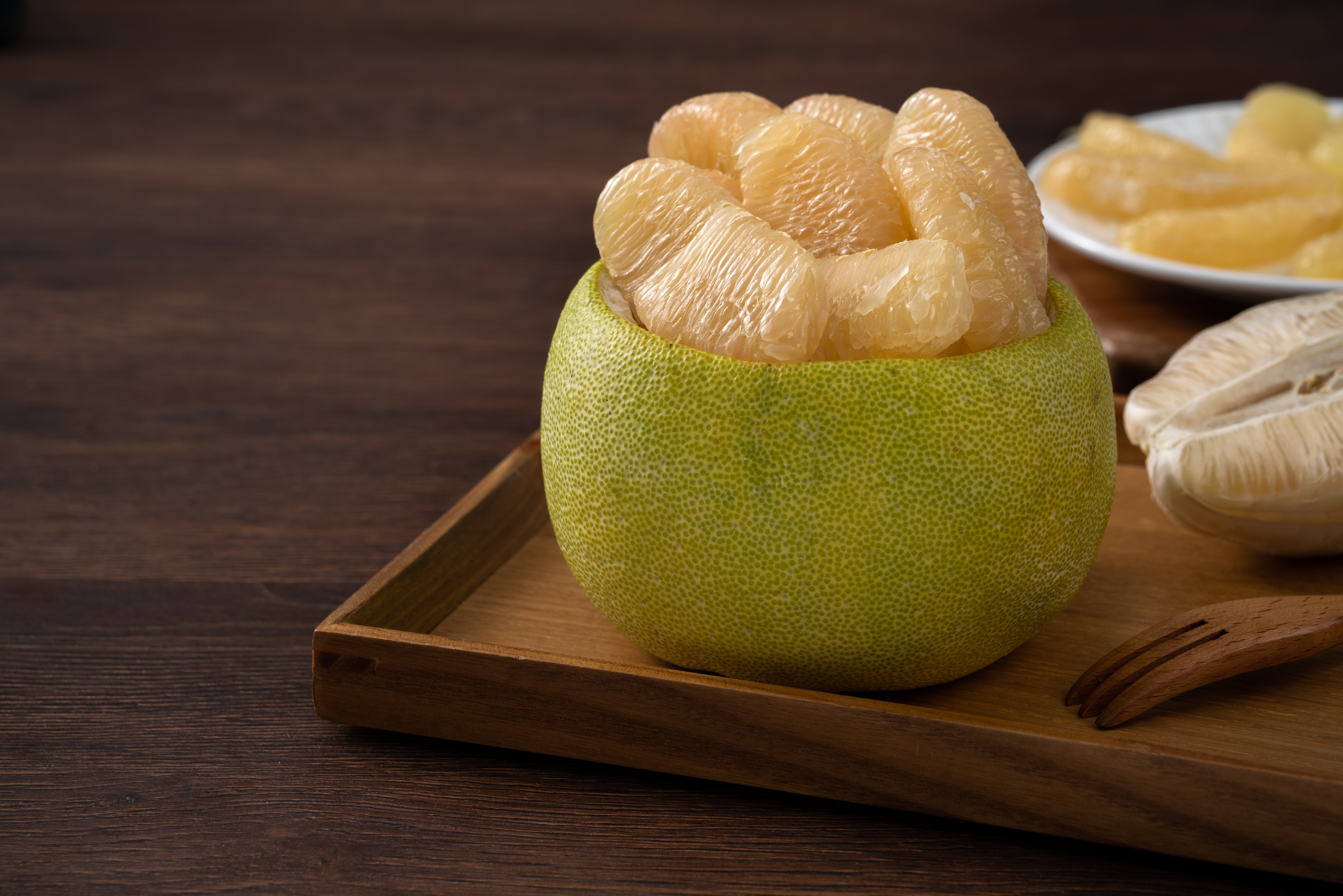 Fresh pomelo fruit on wooden table background.
