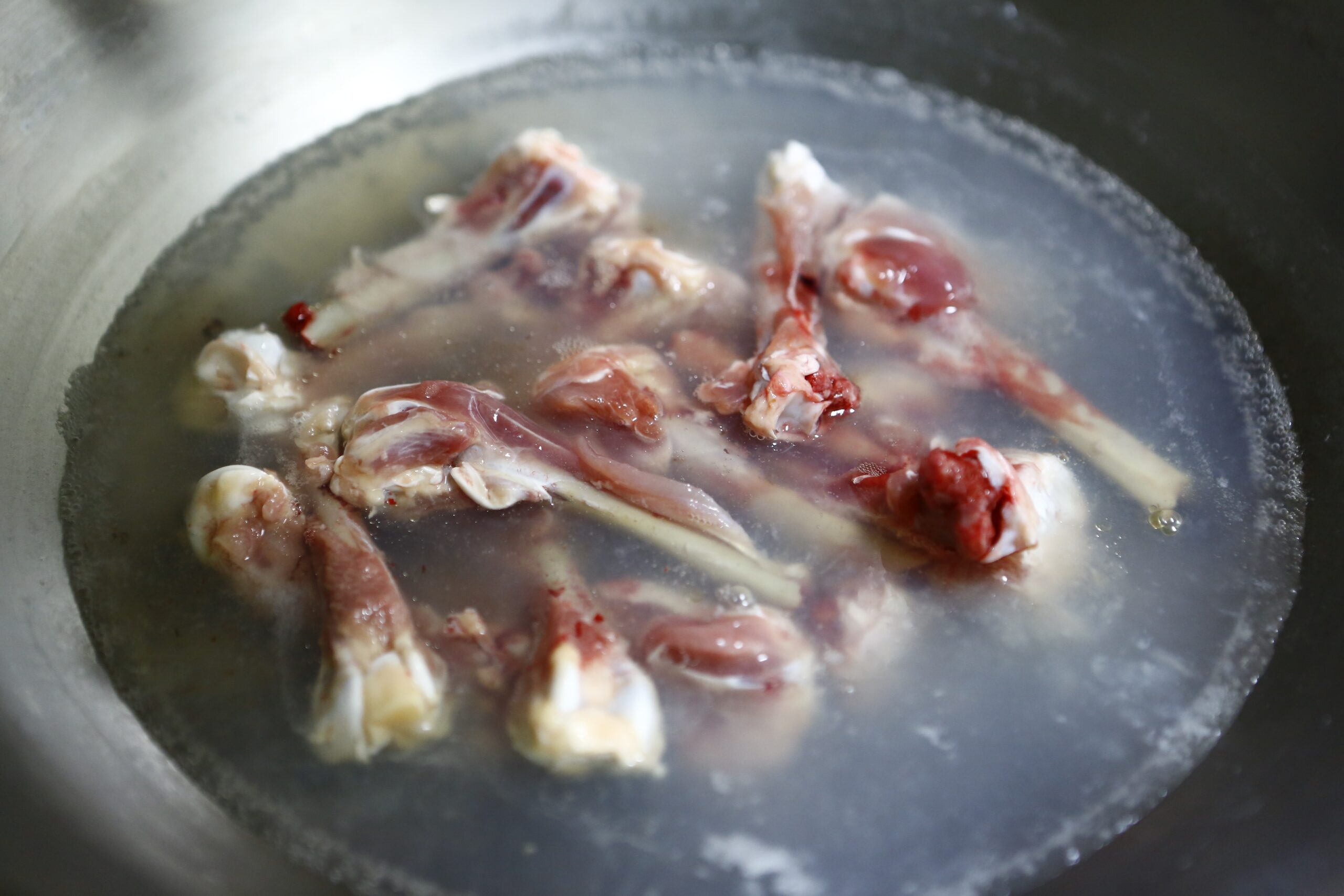 焯水能去除雞骨上的血水和雜質，讓熬出的湯更清澈少雜味，同時也減少湯中的油脂和嘌呤含量。